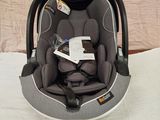 un siège auto pour bébé posé sur un lit, avec un livre à l'intérieur