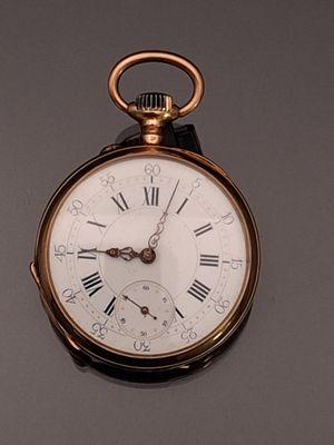 a gold pocket watch with roman numerals on the face