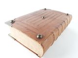 a small wooden book with metal studs on it