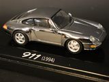 a silver model of a car on display on a black surface