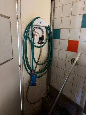 a hose attached to a wall in a bathroom