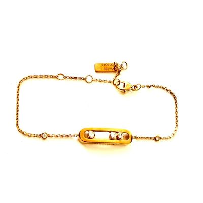 Gros plan sur un bracelet en or orné d'une barre