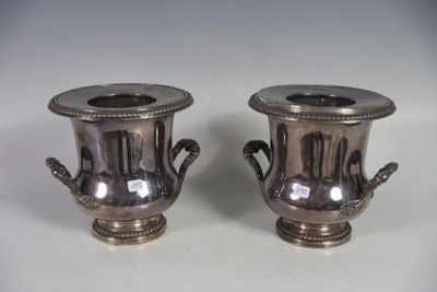 two silver vases that are sitting on a table