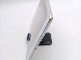 a tablet computer sitting on a stand on a white surface