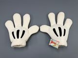 deux gants Mickey Mouse posés sur une surface grise, avec une étiquette
