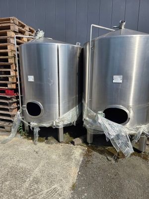 deux cuves en acier inoxydable placées côte à côte devant un bâtiment