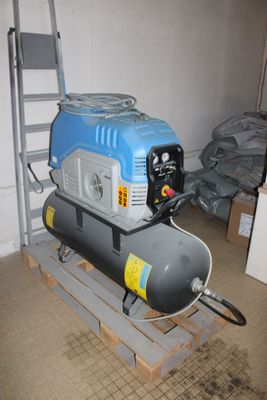 a small air compressor sitting on a pallet in a room