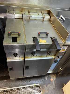 une photo d'une friteuse professionnelle installée dans une cuisine, près d'une porte