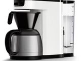 the coffee maker is white and black on a white background