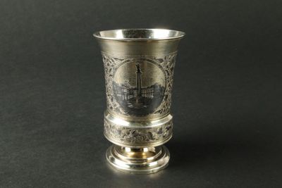 une coupe en argent ornée d'une image, posée sur une table