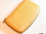 une photo d'un sac à main jaune posé sur une table blanche
