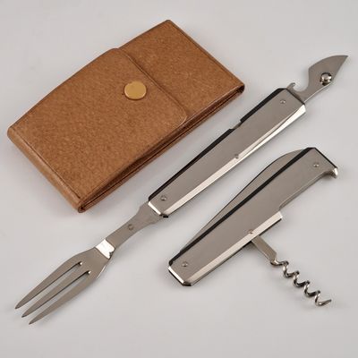trois types de couteaux différents et un portefeuille sur la table