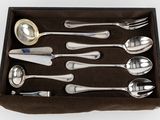six silver spoons in a box with a spoon and spoon rest