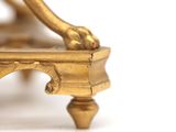 a close up of a gold clock on a white surface