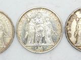 three different types of silver coins are shown on a white surface