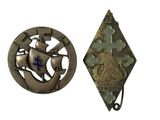 deux morceaux de métal sur lesquels figurent une croix bleue et un bateau