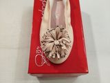 La boîte à chaussures est ouverte et contient une paire de chaussures.