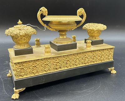 un vase en or et en argent et deux vases posés sur un socle