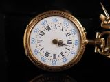 a gold pocket watch with roman numerals on it
