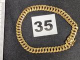 une photo d'un bracelet en chaîne dorée sur lequel figure le chiffre 35