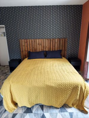 a bed that has a yellow blanket on it