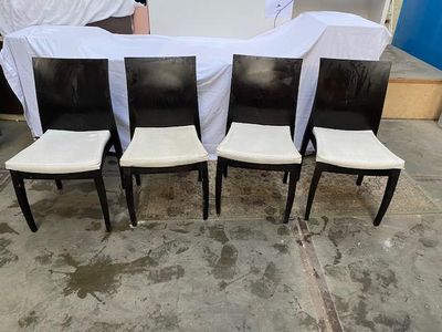 quatre chaises noires et blanches recouvertes de housses blanches