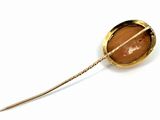 a gold brooch with a brown stone in it