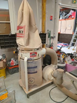 un aspirateur dans le garage, surmonté d'un sac à poussière