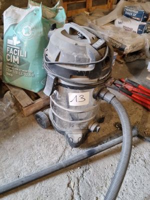 un aspirateur posé par terre à côté d'un sac