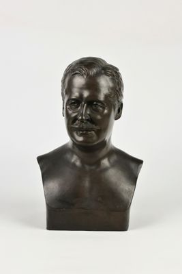 un buste en bronze représentant un homme moustachu sur fond blanc