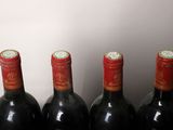 four bottles of wine are lined up in a row on a table