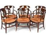 quatre chaises en bois avec un dossier en rotin et une assise en bois