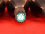 several bottles of wine are lined up in a row on a red surface