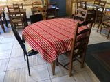 tables and chairs in a restaurant with a red checkered table cloth