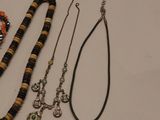 a lot of necklaces and bracelets laid out on a table