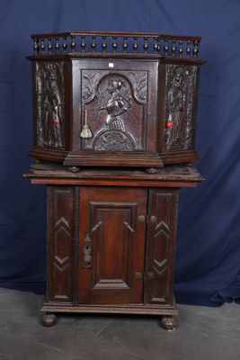 une vieille armoire en bois ornée de sculptures sur le dessus
