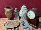 une table sur laquelle se trouvent une horloge, des figurines et d'autres objets