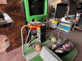 une borne d'arcade verte posée sur un tapis vert
