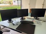 two computer monitors sitting on a desk with a mouse and keyboard