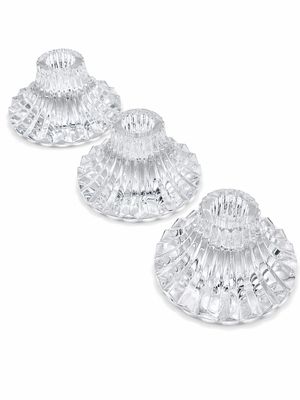 trois bougeoirs en verre transparent sur fond blanc