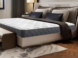 un lit sur lequel est posé un matelas dans une pièce