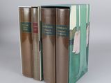 three books are stacked on top of each other on a white surface