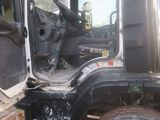a truck that is parked in the dirt with its door open