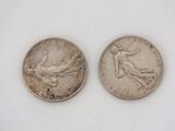 an image of two silver coins sitting side by side on a white surface