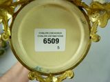 a close up of a gold vase with a label on it