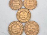 five gold coins with the names of different countries on them