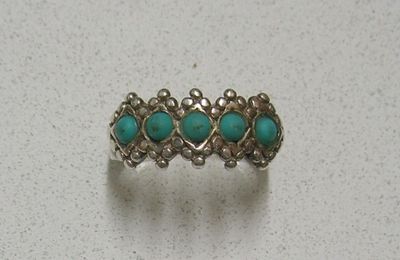 un gros plan d'une bague en argent sertie de pierres de turquoise