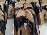 many pairs of black sandals with bows on them