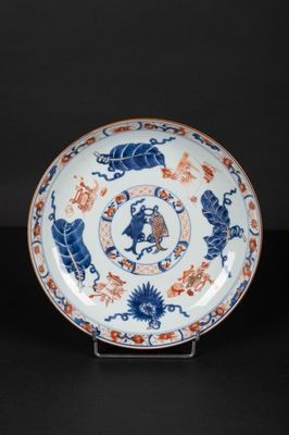 a blue and white plate with a design of lions and flowers