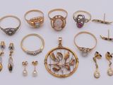 various rings and earrings are arranged on a white surface